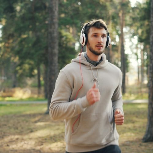 Man with headphones running in a forest
