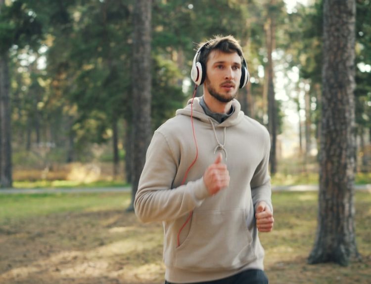 Man with headphones running in a forest