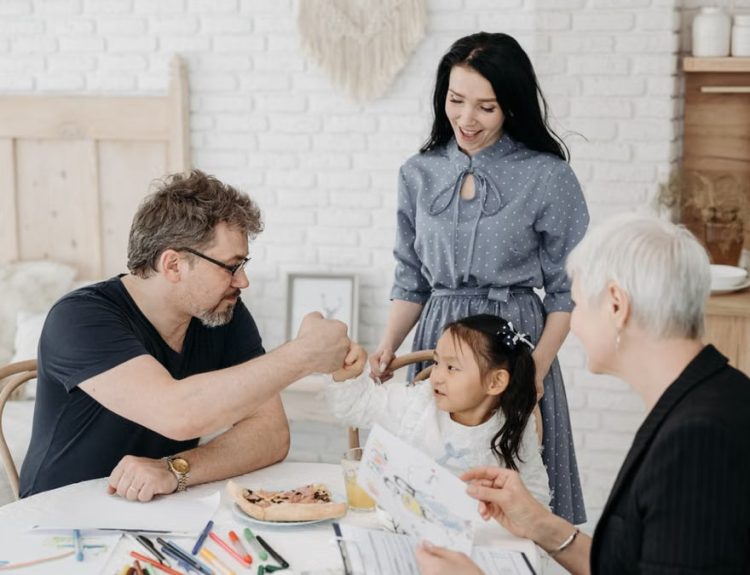 Child with foster parents and a social worker discussing adoption at home.