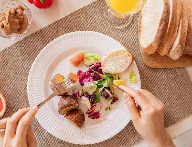 Top view of a nutritious breakfast setup with salad, bread, and fresh juice, perfect for a healthy start.