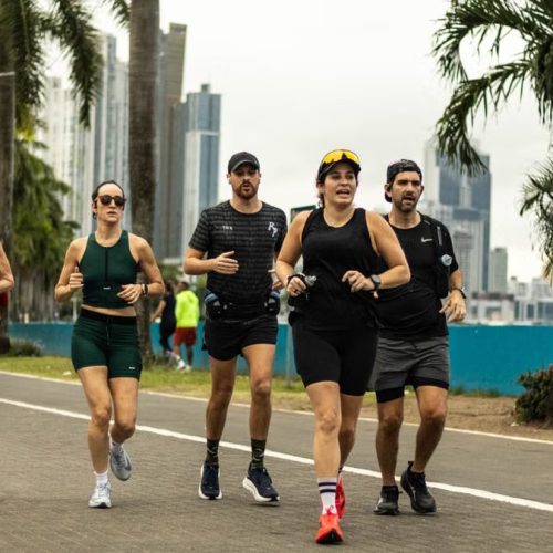A group of diverse runners jogging along a scenic city pathway in Panama City, promoting healthy lifestyle.